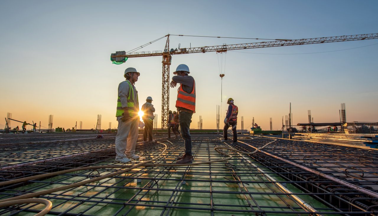 Construction engineer working at construction site during sunset time